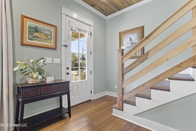 entrance foyer featuring wood finished floors, stairs, baseboards, and ornamental molding