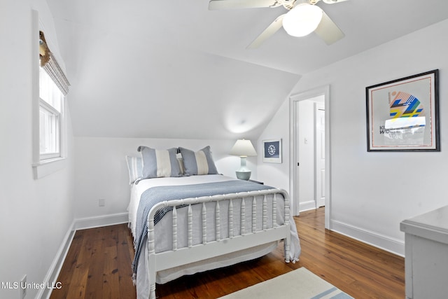 bedroom featuring lofted ceiling, baseboards, and wood finished floors