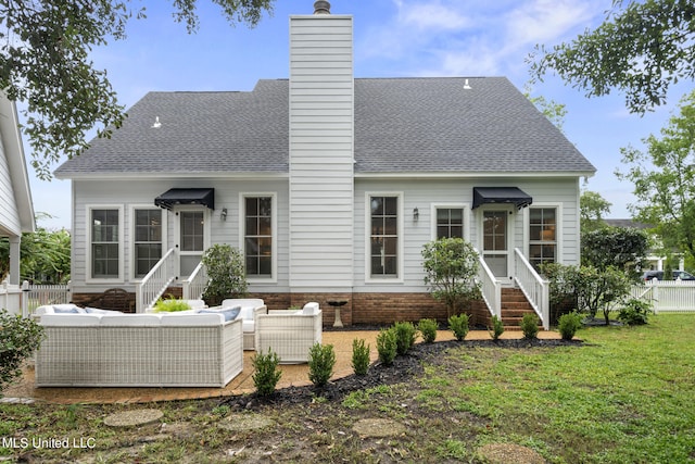 rear view of property featuring entry steps, a chimney, fence, and outdoor lounge area