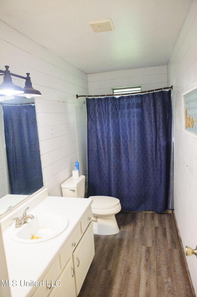 1639 Pascagoula River Rd, Moss Point, MS 39562 - full bath featuring wood finished floors, vanity, toilet, and a shower with shower curtain