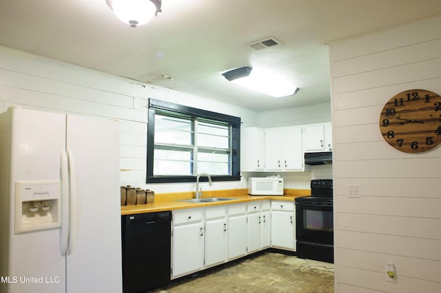 1639 Pascagoula River Rd, Moss Point, MS 39562 - kitchen with black appliances, under cabinet range hood, a sink, wooden walls, and white cabinetry