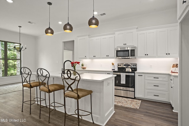 kitchen with a kitchen island with sink, visible vents, appliances with stainless steel finishes, dark wood finished floors, and white cabinets
