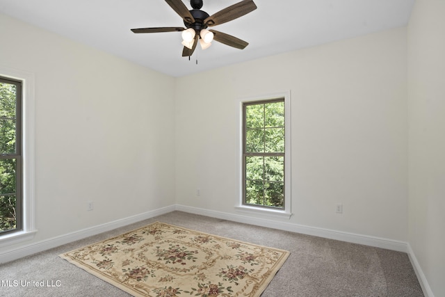 unfurnished room featuring plenty of natural light, a ceiling fan, and light colored carpet