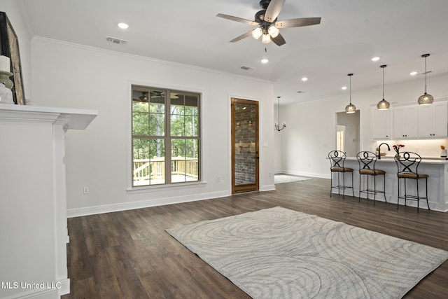 living room featuring a ceiling fan, visible vents, crown molding, baseboards, and dark wood-style floors