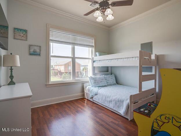 bedroom with ceiling fan, baseboards, wood finished floors, and ornamental molding