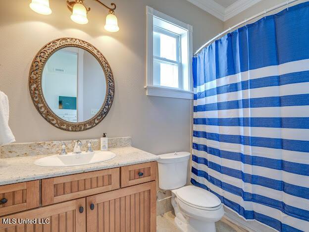 full bath featuring a shower with shower curtain, crown molding, toilet, and vanity