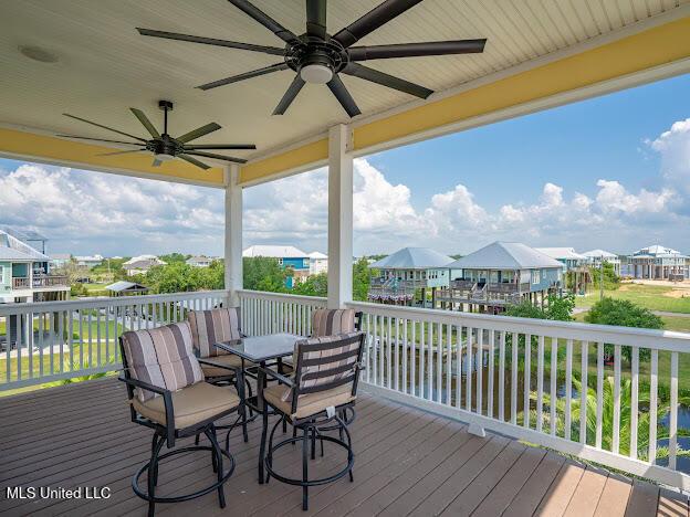 wooden deck with outdoor dining area, a residential view, and a ceiling fan