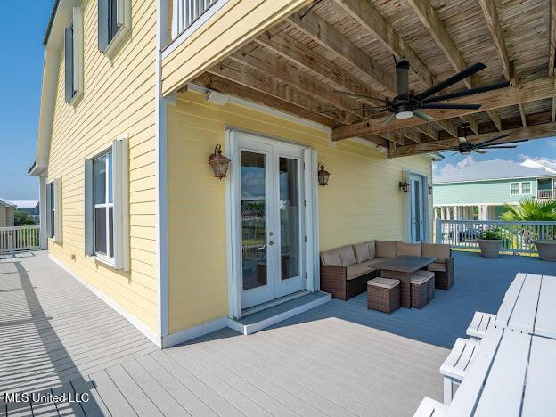 wooden terrace with french doors, outdoor lounge area, and a ceiling fan