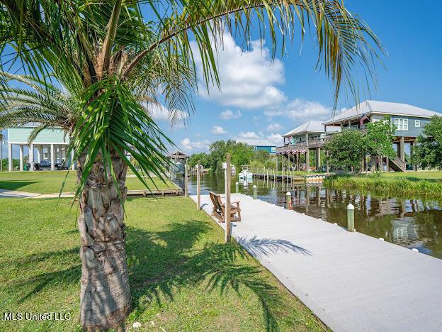 dock area with a lawn and a water view