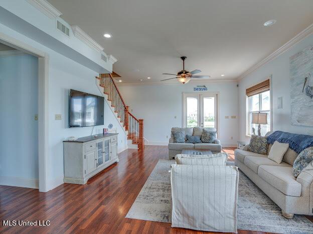 living area featuring visible vents, baseboards, stairs, ornamental molding, and dark wood-style floors