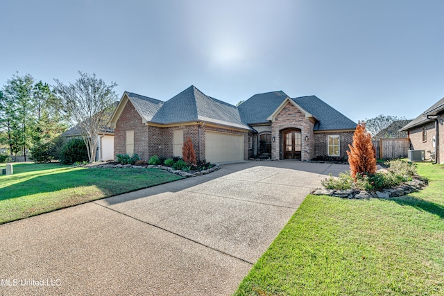 french country style house with a garage, cooling unit, and a front lawn