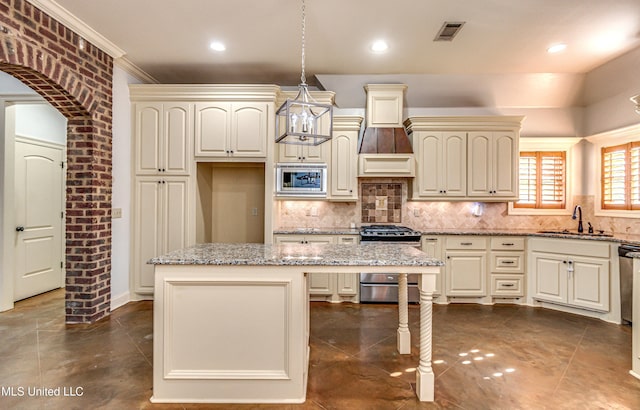 128 Amethyst Ln, Brandon, MS 39047 - kitchen with appliances with stainless steel finishes, a sink, decorative backsplash, cream cabinetry, and light stone countertops