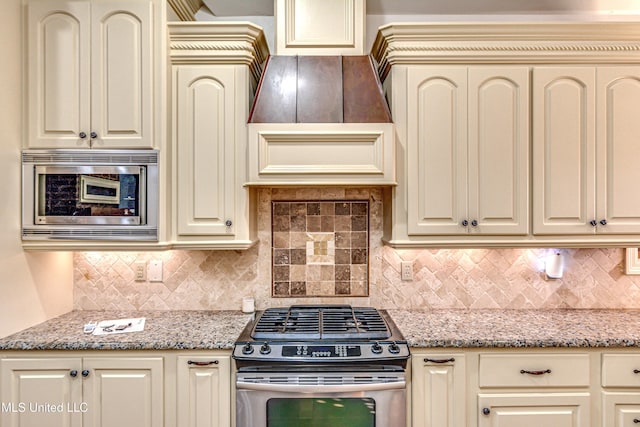 128 Amethyst Ln, Brandon, MS 39047 - kitchen with stainless steel appliances, cream cabinetry, tasteful backsplash, and light stone countertops