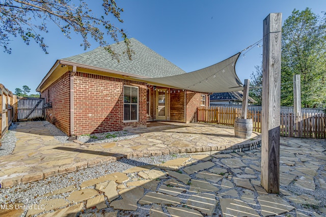 128 Amethyst Ln, Brandon, MS 39047 - back of house with brick siding, a patio area, roof with shingles, and a fenced backyard