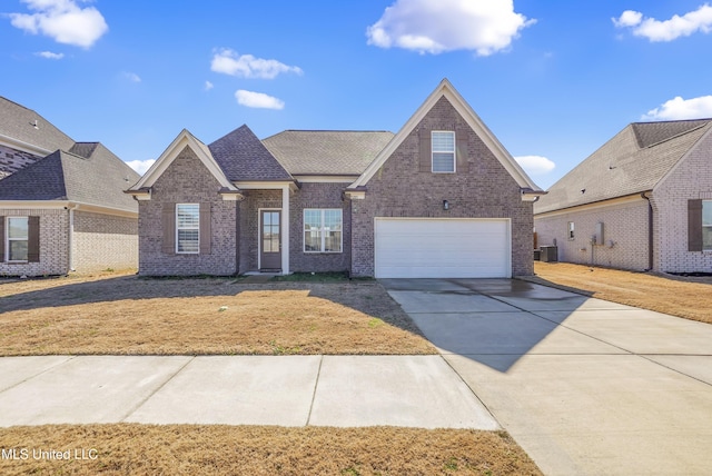 traditional-style house featuring a front yard, brick siding, driveway, and an attached garage