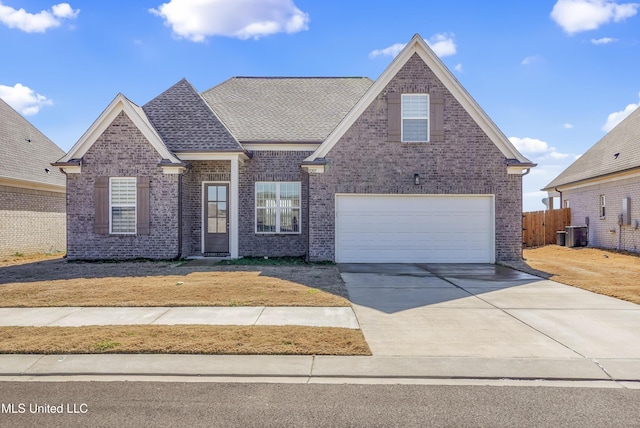 traditional home featuring driveway, brick siding, a shingled roof, and fence