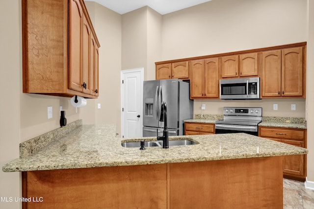 4813 Rosepetal Cv, Southaven, MS 38672 - kitchen with appliances with stainless steel finishes, light stone counters, a sink, brown cabinetry, and a peninsula