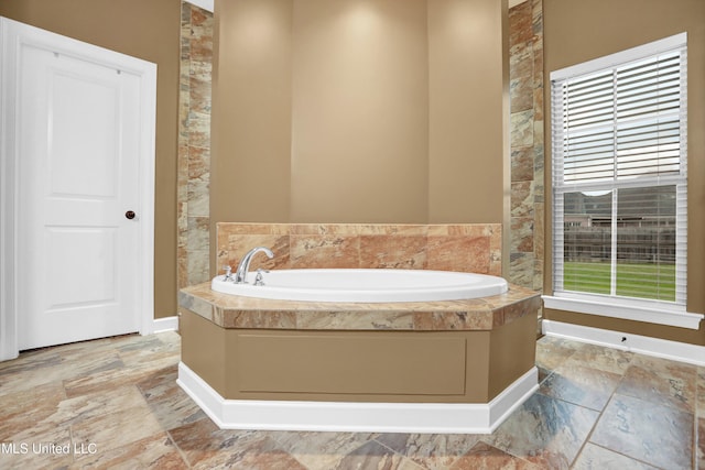 4813 Rosepetal Cv, Southaven, MS 38672 - full bathroom featuring a garden tub, baseboards, and stone tile flooring