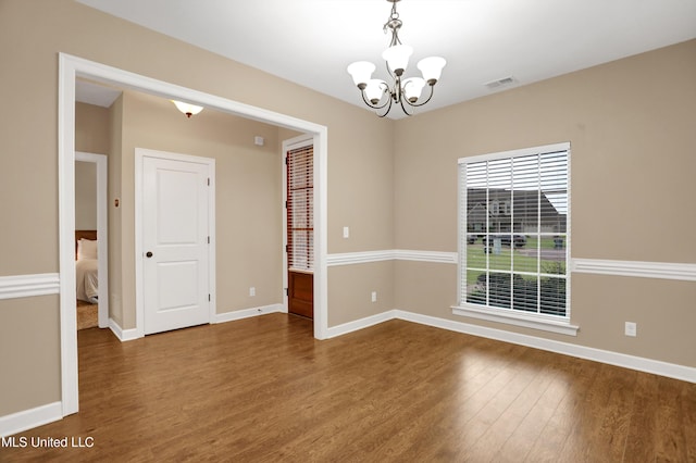 4813 Rosepetal Cv, Southaven, MS 38672 - spare room featuring baseboards, a notable chandelier, dark wood-style floors, and visible vents