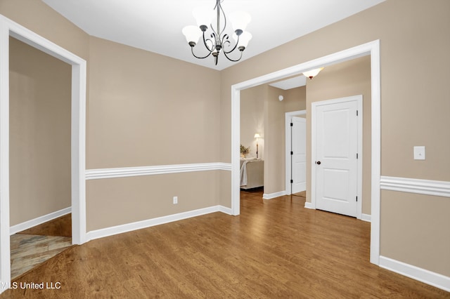 4813 Rosepetal Cv, Southaven, MS 38672 - unfurnished room featuring baseboards, an inviting chandelier, and wood finished floors
