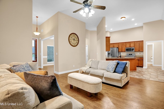 4813 Rosepetal Cv, Southaven, MS 38672 - living room with a ceiling fan, baseboards, light wood-style floors, and a towering ceiling