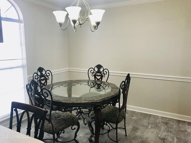 dining area with an inviting chandelier, baseboards, crown molding, and wood finished floors