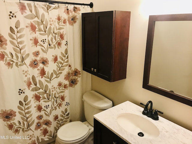 full bath featuring a shower with shower curtain, vanity, and toilet