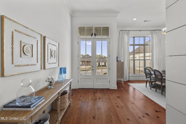doorway to outside with french doors, ornamental molding, wood-type flooring, and visible vents