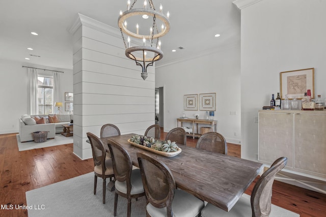 dining room featuring recessed lighting, ornamental molding, wood-type flooring, and a notable chandelier