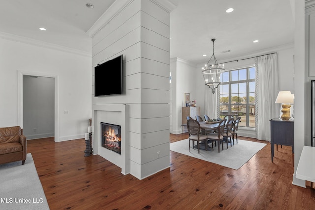 dining area with wood-type flooring, a notable chandelier, and ornamental molding