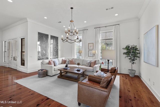 living room featuring ornamental molding, wood finished floors, and a chandelier