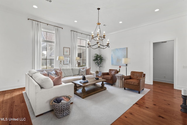 living room featuring an inviting chandelier, baseboards, recessed lighting, and wood finished floors