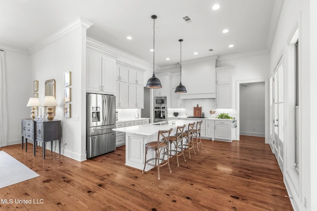 kitchen featuring visible vents, appliances with stainless steel finishes, light countertops, white cabinets, and a breakfast bar