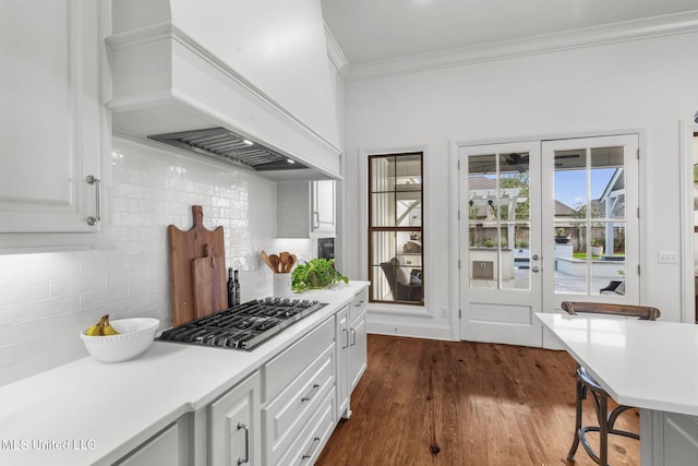 kitchen featuring dark wood-type flooring, light countertops, stainless steel gas cooktop, and premium range hood