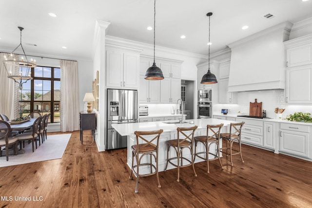 kitchen with a sink, light countertops, ornamental molding, stainless steel appliances, and dark wood-style floors