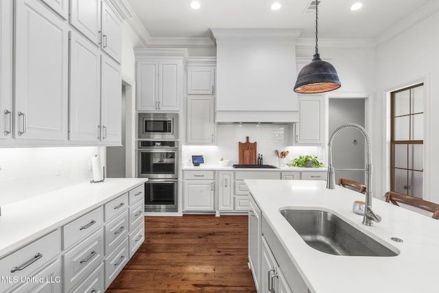kitchen featuring crown molding, stainless steel appliances, a sink, and light countertops