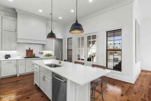 kitchen featuring ornamental molding, dark wood-style floors, light countertops, a sink, and stainless steel appliances