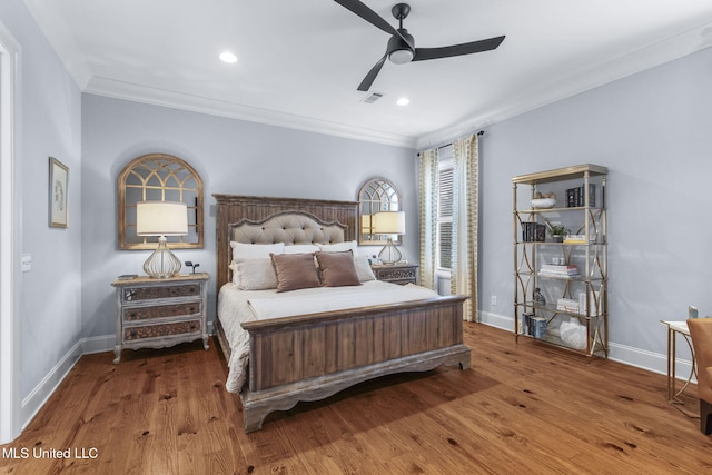bedroom featuring crown molding, baseboards, wood finished floors, and visible vents