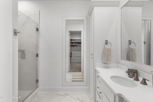 full bath featuring vanity, marble finish floor, baseboards, and a shower stall