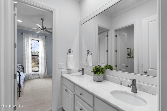bathroom featuring crown molding, double vanity, ceiling fan, and a sink