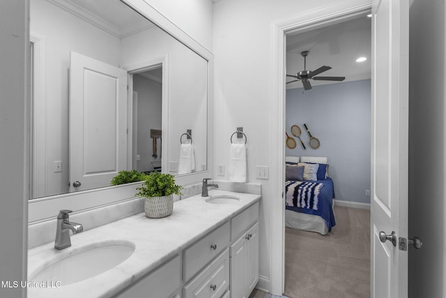ensuite bathroom with double vanity, a sink, a ceiling fan, and ornamental molding