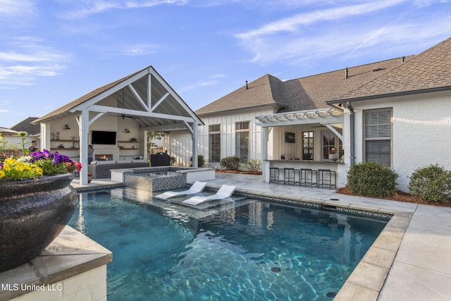 back of property with outdoor dry bar, a shingled roof, a ceiling fan, a patio area, and a pool with connected hot tub