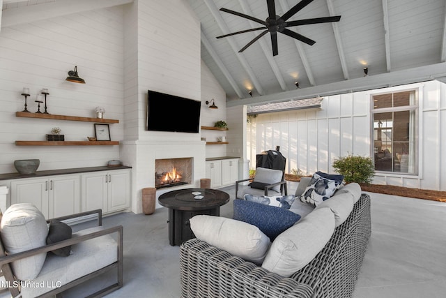 living area featuring finished concrete flooring, beam ceiling, a warm lit fireplace, high vaulted ceiling, and a ceiling fan