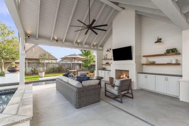 view of patio / terrace featuring a ceiling fan, an outdoor living space with a fireplace, and a fenced backyard