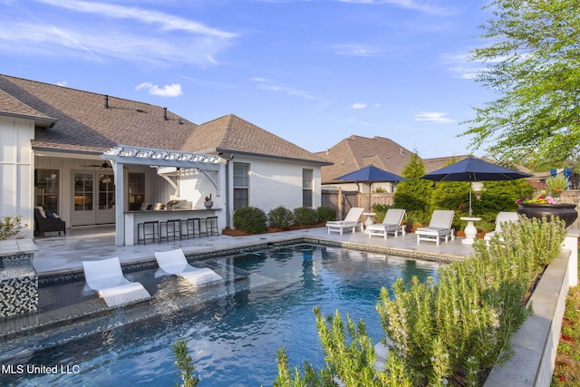 view of swimming pool with a patio area, outdoor dry bar, a fenced in pool, fence, and a pergola
