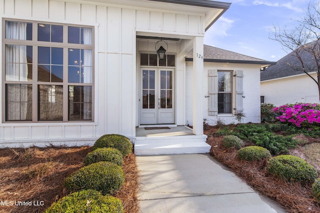 property entrance with a shingled roof and board and batten siding