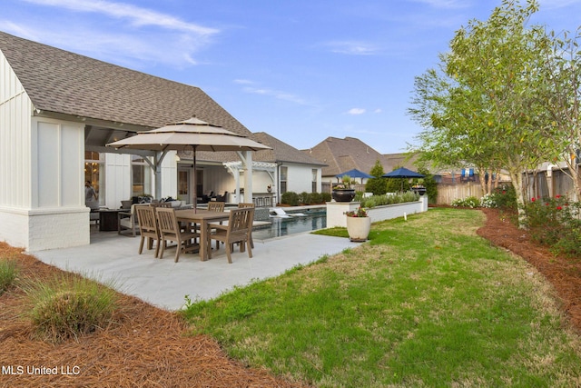 back of house with a gazebo, roof with shingles, a yard, and a patio