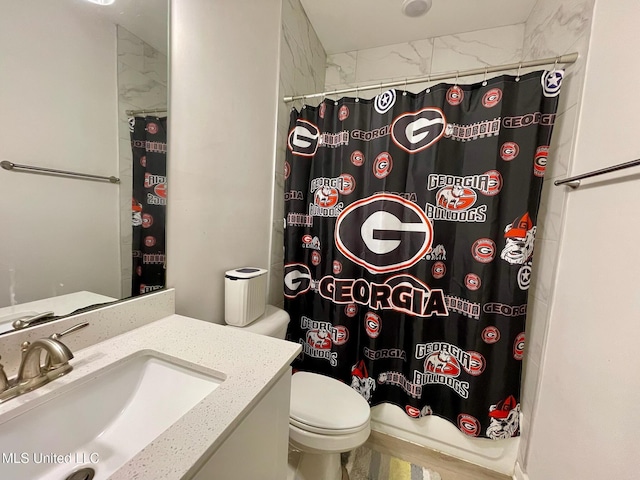 bathroom with toilet, vanity, and curtained shower