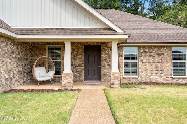 doorway to property with covered porch and a lawn