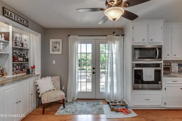 doorway to outside featuring french doors, light wood-type flooring, and ceiling fan